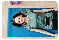 A woman laying on a yoga mat doing a body scan