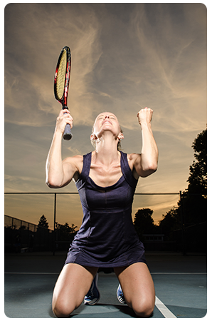 A female tennis playing celebrating victory