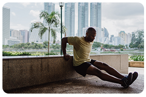 A man doing tricep dips in the park