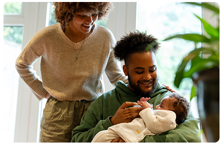 A man holding his baby next to his wife