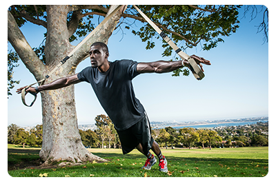 A man using a band on a tree to do exercises