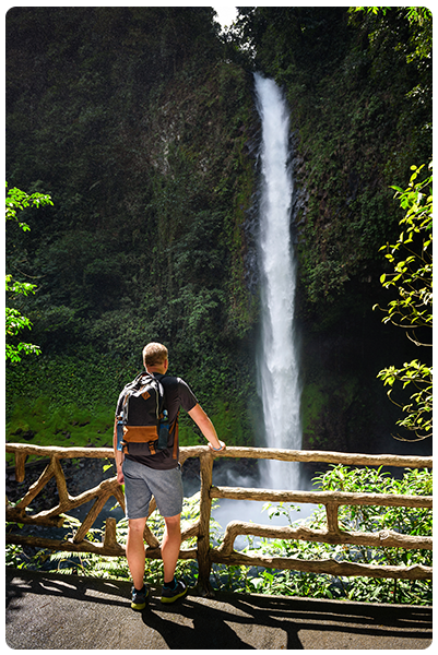 A man hiking next to a waterfall