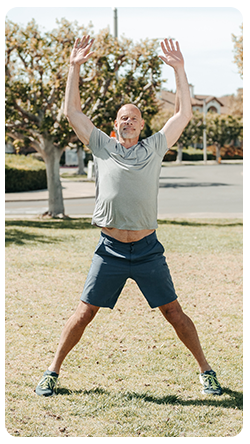 A man doing jumping jacks in the park