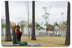 A guy doing yoga and stretching in the park