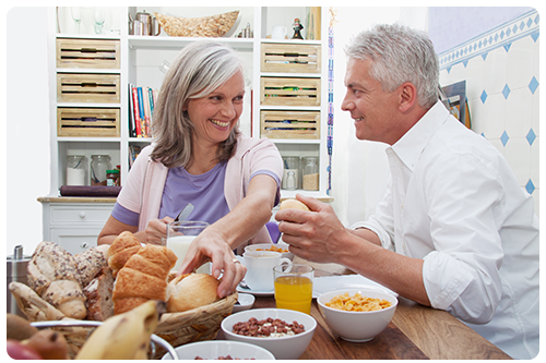 A couple sitting at a table eating breakfast