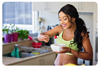 A woman eating in her kitchen