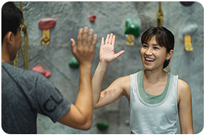 I man and a woman in front of a rock walk congratulating each other