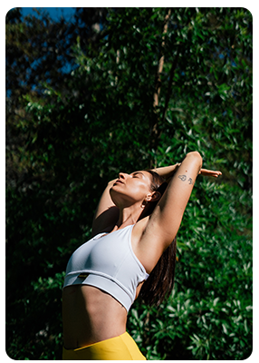 A woman standing outside stretching